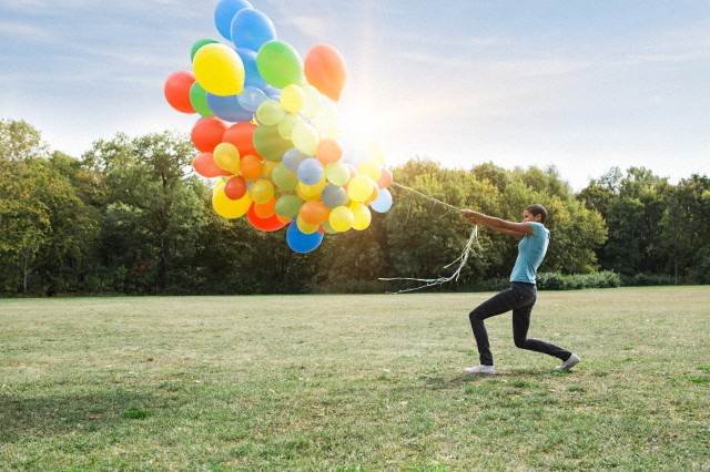 Woman pulling colorful balloons