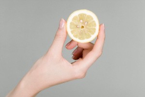 Woman holding lemon slice --- Image by © Sung-Il Kim/Corbis