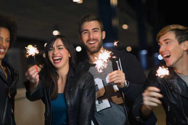 Friends celebrating New Year's Eve with sparklers outdoors