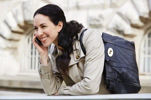 Mid-adult woman talking on phone during her work break