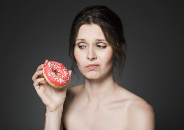 Doubtful woman with donut